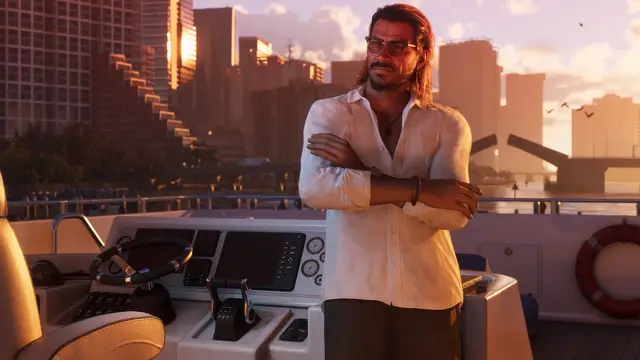 Raul Bautista with his arms crossed on the deck of a boat, city towers behind him at sunset