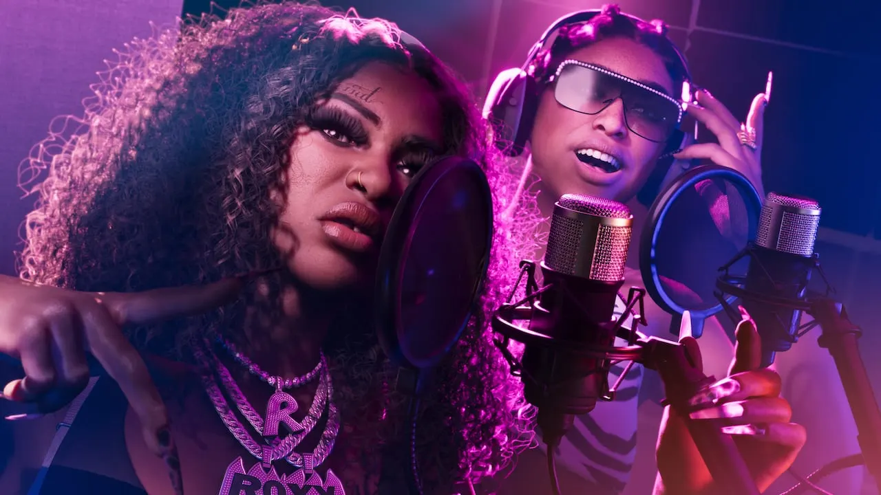 Bae-Luxe and Roxy of Real Dimez at studio microphones under purple light